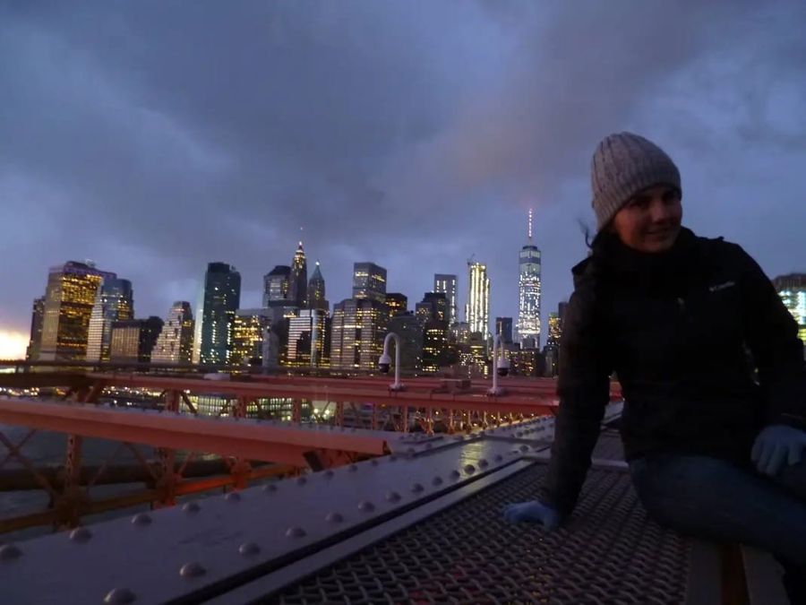 Diana en el puente de Brooklyn, con el skyline de Nueva York al atardecer
